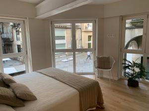 a bedroom with a bed and a large window at LAS TERRAZAS I Lujo frente a la plaza de Santa Eufemia in Ourense