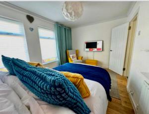 a bedroom with a bed with a blue blanket on it at Bloom19 Traditional Belfast Entire House 10 mins from City Centre in Belfast