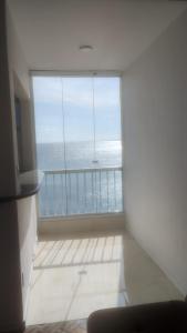 een groot raam in een kamer met uitzicht op de oceaan bij Apartamento Vista Farol da Barra com 2 Quartos in Salvador