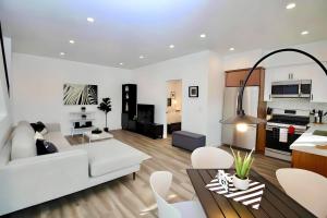 Los Angeles 3BR Villa Suites with Free Parking في لوس أنجلوس: غرفة معيشة مع أريكة بيضاء وطاولة