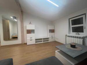 sala de estar con paredes blancas y suelo de madera. en BELWEDER 12, en Warlubie