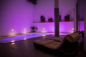 uma piscina num quarto com iluminação roxa em Apartment with luxurious pool 5 mins walk from the beach em Naxxar