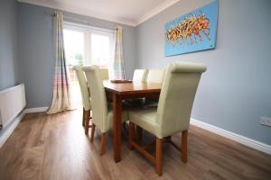 a dining room with a wooden table and chairs at Spacious 3BR House Cardiff - Free Parking for 3 cars - Fast Internet in Cardiff