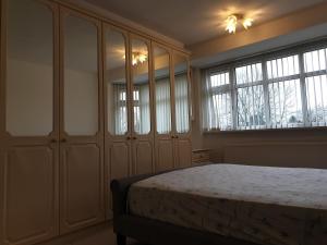 a bedroom with a bed and some windows at Spencefield House in Leicester