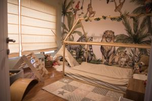 um quarto infantil com uma cama com um mural de cães em Apartment with luxurious pool 5 mins walk from the beach em Naxxar