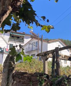 una casa en el fondo con un árbol en Casa SuasDuas, en Vila Cova de Alva