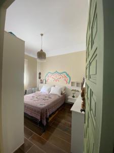 a bedroom with a bed with a pink headboard at Casa Cruz in Gelves