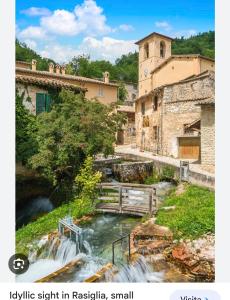 una piccola cascata in una piccola cittadina con un fiume di Affitta camere Via Piave a Foligno