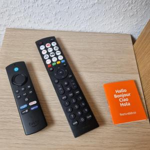 two remote controls and a book on a table at Exklusives Apartment nah S-Bahn in Bochum