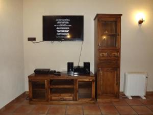 un escritorio de madera frente a una pared con TV en Casa Rural "Los Herrero", en Zarzuela del Monte