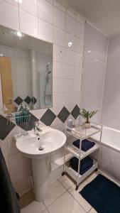 a bathroom with a sink and a mirror and a tub at Excellent Leeds City Centre 1 Bedroom Apartment in Leeds