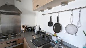 a kitchen with a sink and pots and pans on the wall at Excellent Leeds City Centre 1 Bedroom Apartment in Leeds