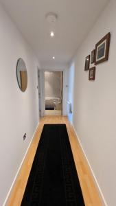 a hallway with white walls and a black rug at Excellent Leeds City Centre 1 Bedroom Apartment in Leeds
