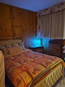 a bedroom with a bed with a colorful comforter at La Finestrella Alpina in Piancavallo