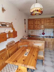 a kitchen with a wooden table in the middle at La Finestrella Alpina in Piancavallo