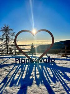 a heart shaped sign in the snow with the sun at La Finestrella Alpina in Piancavallo