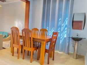 uma mesa de jantar em madeira com 4 cadeiras e um lavatório em 3bedrooms Home in Musanze em Cyuve