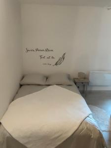 a bedroom with a bed with a sign on the wall at Le petit Migault in La Creche