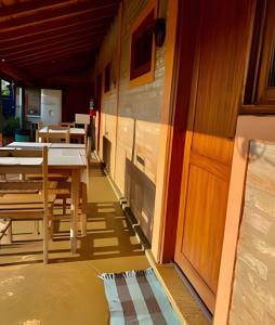 einen Flur mit Tischen und Stühlen und einer Tür in der Unterkunft Pousada Recanto Janbor in Olímpia