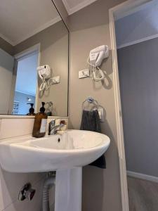 La salle de bains est pourvue d'un lavabo blanc et d'un miroir. dans l'établissement Moderno Departamento, à Osorno