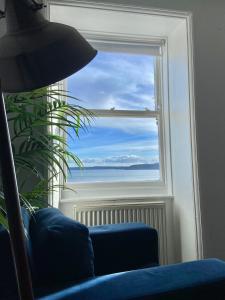 a room with a blue couch and a window at Waimea Apartments - Sea Views South Bay Scarborough Free Parking in Scarborough