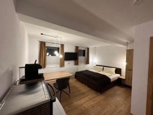 a bedroom with a bed and a desk in a room at Willi's Holidays Home in Saalbach-Hinterglemm
