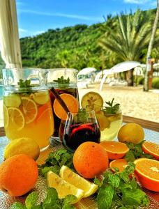 a table with oranges and drinks on a beach at Seven Secrets by Hanging Gardens in Senggigi 