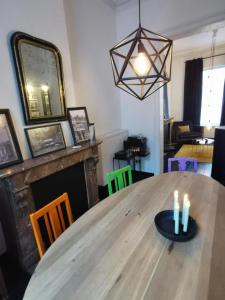 a dining room with a wooden table with candles on it at Chantilly Townhouse in Ghent