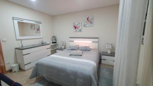 una camera con un grande letto e uno specchio di apartamento T2 zona rural a Vila Nova de Paiva