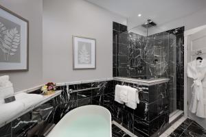 uma casa de banho em preto e branco com um chuveiro e um lavatório em Rockport Harbor Hotel em Rockport
