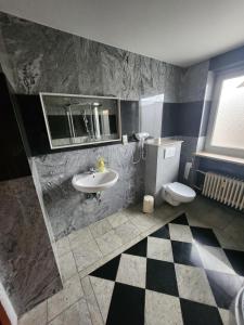 a bathroom with a sink and a toilet at Pension Doppelzimmer mit Balkon 24 