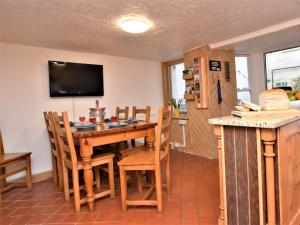 a dining room with a wooden table and chairs at 3 Bed in Ilfracombe 66239 in Ilfracombe