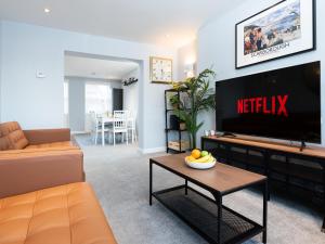 sala de estar con TV, sofá y mesa en Waimea Apartments - Sea Views South Bay Scarborough Free Parking en Scarborough