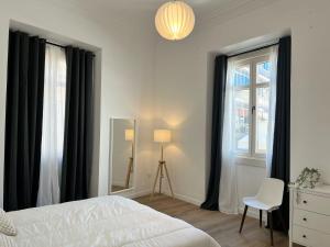 a bedroom with black curtains and a bed and a chair at Suites Larios in Málaga +35 photos