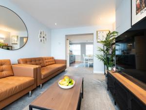 sala de estar con sofá y mesa con un bol de fruta en Waimea Apartments - Sea Views South Bay Scarborough Free Parking en Scarborough