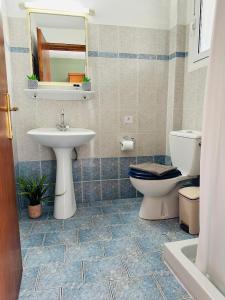 W łazience znajduje się umywalka, toaleta i lustro. w obiekcie Melitsa corfu hotel w Sidari