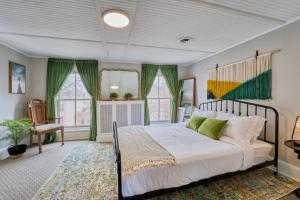 a bedroom with a large bed with green curtains at 1 Bedroom Treetop Apartment on Capitol Hill! in Washington