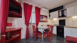 a kitchen with red chairs and a table in a kitchen at Red blue with private parking and Gray blue apartment in Pula