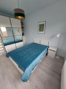 sypialnia z łóżkiem z niebieską kołdrą w obiekcie Krapkowice Odrzańskie Tarasy w mieście Krapkowice