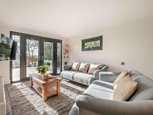 a living room with two couches and a table at 3 Bed in Damerham 93357 in Damerham