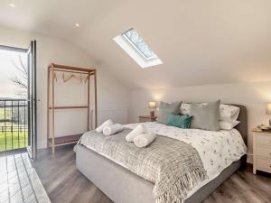 1 dormitorio con 1 cama grande y tragaluz en 3 Bed in Damerham 93357 en Damerham