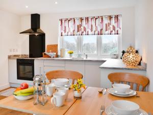 a kitchen with a wooden table with chairs and a wooden table sidx sidx at Cartwheel Cottage in Hayton