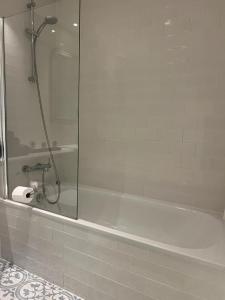 uma casa de banho com um chuveiro e uma banheira branca em Delightful & Spacious Flat in London - Peckham em Londres