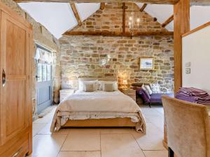 a bedroom with a bed and a stone wall at 2 Bed in Helmsley 93098 in Chop Gate