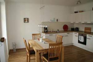 a kitchen with a wooden table and chairs in it at Ferienwohnung Kröning in Stralsund