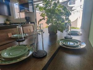 een houten tafel met groene borden en glazen erop bij Casa Meraki in Querétaro
