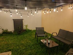un patio con 2 sillas, una mesa y luces en Casa Meraki, en Querétaro