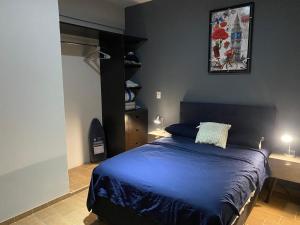 SayulaにあるSayula luxury apartmentsのベッドルーム1室(青いシーツと照明2つ付)
