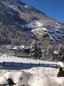 a snow covered mountain with a house in the foreground at paisible appartement près des pistes in La Salle Les Alpes