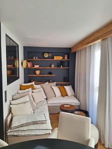 a living room with a white couch and chairs at paisible appartement près des pistes in La Salle Les Alpes